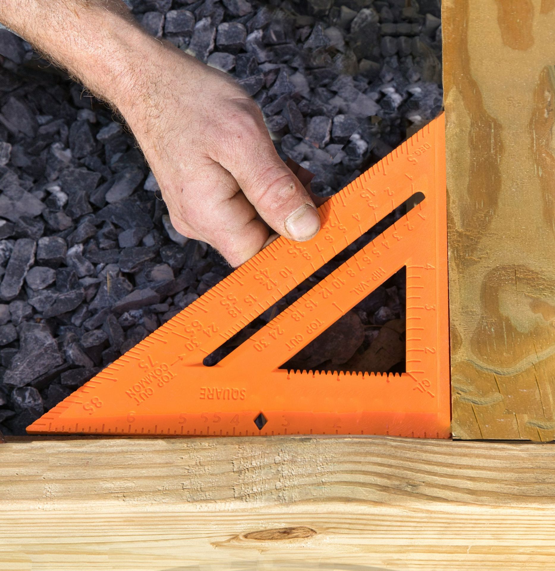 a person measuring a piece of wood with a ruler